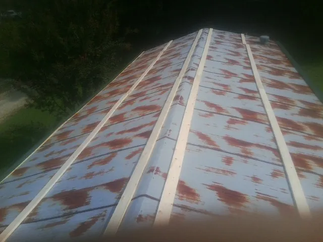 Rusted metal roof panels with new wood purlins before replacement — Storm Damage Roof Repair in Paisley by Roofing Brothers