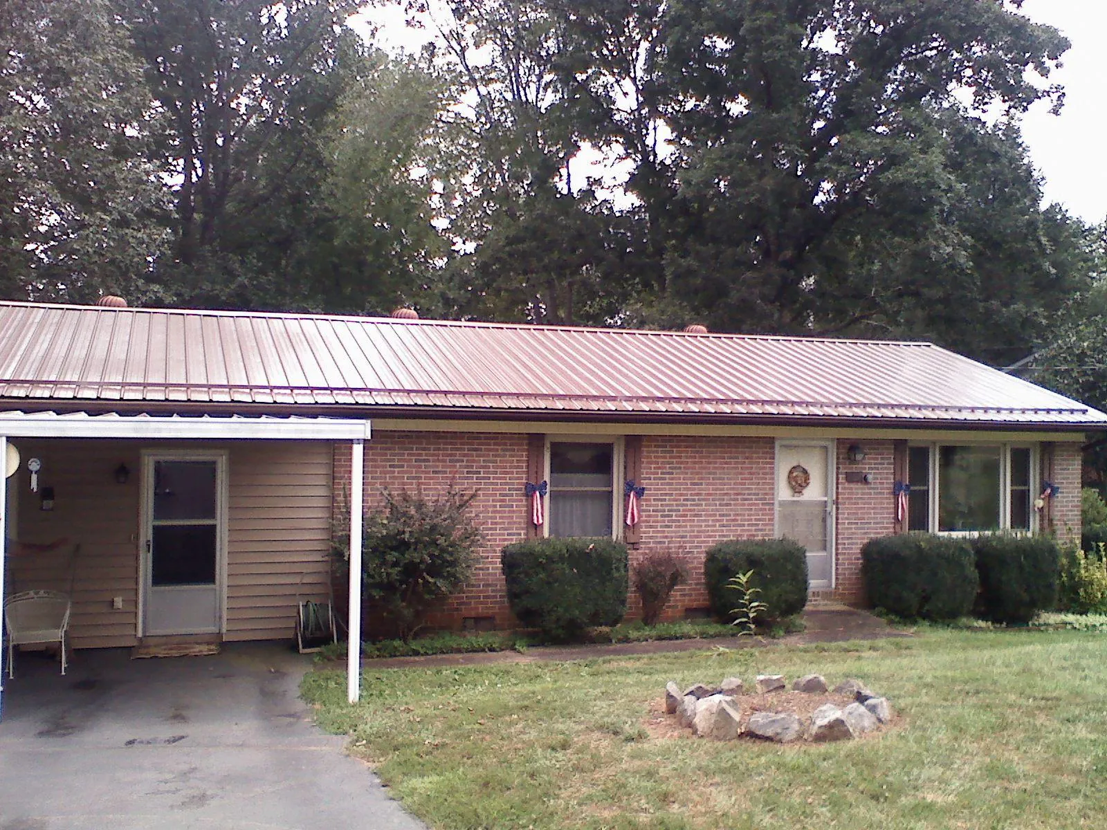Bronze metal roof and carport on a brick ranch home — Roof Repair work by our crew in Paisley